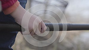 Close-up of little male Caucasian hand holding rod. Unrecognizable boy fishing outdoors on cloudy day. Hobby, lifestyle