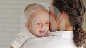 Close-up of a little newborn baby crying, mom calms him down.