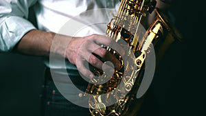 Close up locked down shot of musician playing saxophone in studio.