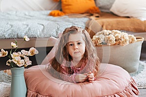 Close up lonely little girl in bedroom with toys, stay at home alone, upset unhappy child waiting for parents