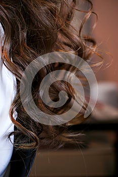 Close up of long brunette hair curled with iron flat