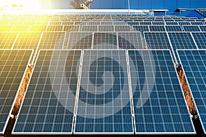 Close-up of a lot of industrial solar panels for the production of electricity against the background of an enterprise or factory