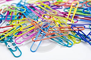 Close-up a lot of variety color of paper clips on white background