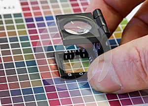 Close-up of a loupe on a colorful test print