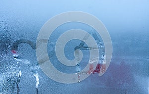 Close-up on love heart and home condensation lettering against sweaty window glass. Hand draws a heart and a house on a foggy