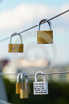 Close up of lovelocks hanging on metal fence