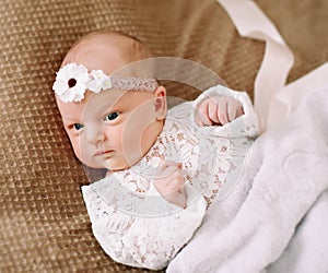 Close-up lovely newborn baby girl on a blanket. A portrait of a beautiful  newborn baby girl wearing a headband. Closeup photo