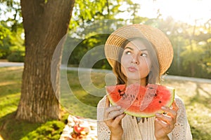 Close up of lovely young girl in summer hat spending time at the park,