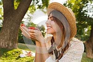 Close up of lovely young girl in summer hat spending time at the park,