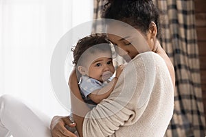 Close up loving African American mother holding toddler daughter