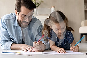 Close up loving father with adorable little daughter drawing together