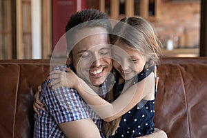 Close up loving father and daughter hugging, enjoying tender moment