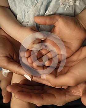 Close up of loving mom dad and kid hold hands on floor palms up together express closeness and unity, caring parents