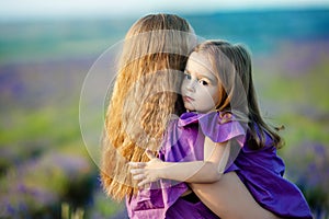 Close up of loving mother and baby posing in flowering field