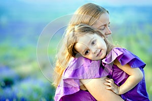 Close up of loving mother and baby posing in flowering field