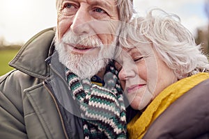 Close Up Of Loving Senior Couple Enjoying Autumn Or Winter Walk Through Park Together