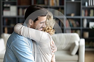 Close up loving young man hugging mature mother at home