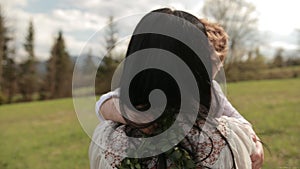 Close-up loving young mother hugging, calming little son who is crying outdoors