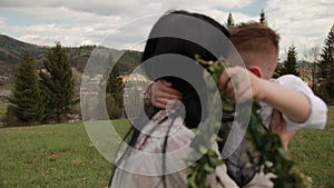 Close-up loving young mother hugging, calming little son who is crying outdoors