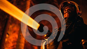 Close Up Low Angle Creative Portrait of a Brave African American Firefighter Using a Firehose to