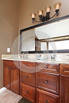 Close up luxury wood bathroom cabinets and mirror.