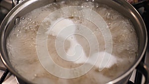 close up of a macaroni Italian food recipe preparation in a pot with boiling and bubbling water