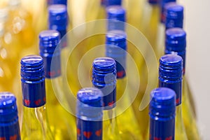 Close up / macro of bottles with blue cap containing a yellow liquid