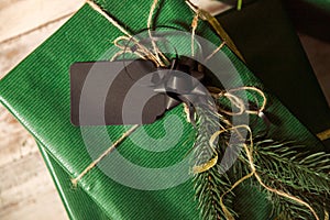 Close up, macro. Christmas concept. Gift green packing box. Tied with black ribbons, an empty business card on top