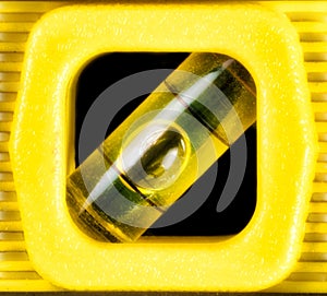 Close up macro of glowing yellow level tool with bubble in glass