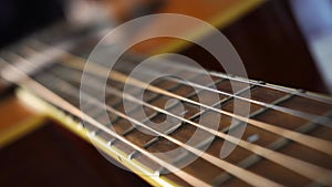 Close up macro on guitar strings or chords with very slow movement or panning. Musical instrument. Music and sound concept