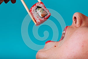 Close up macro of lips with Sushi roll. Lady eating japanese food