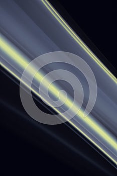 A close up macro photo of a diagonal wisp of smoke lit with blue and yellow flash gels on a black background that makes an