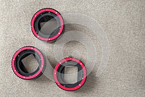 Close-up of macro rings, camera adapters on light cloth copy space background. Modern technology and photography equipment concept
