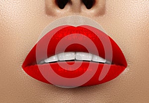 Close-up macro shot of female mouth. Glamour red lips Makeup with sensuality gesture. Bloody lipstick