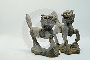 Close-up macro shot of a pair of bronze Chinese Qilin figurines, on white background