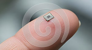 Tiny Microchip on Human Finger Macro.