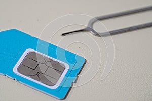 Close up macro of SIM card and SIM tray ejector tool