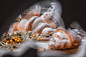 Close up. Valentine`s Day. Romantic breakfast with french croissants and hot tea. View through a carved wooden folding screen