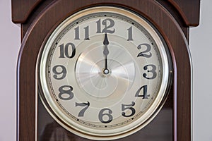 Close up macro view of brown clock with light clock face showing  twelve  o`clock. Time concept. Postcard.