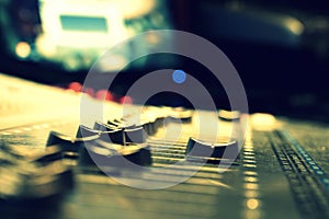 A close up macro view of faders on a mixing board in a studio