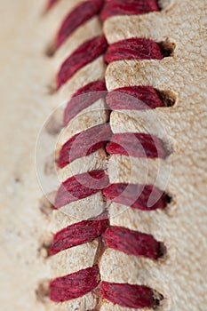 Close up macro view of red stitched seams of an worn baseball