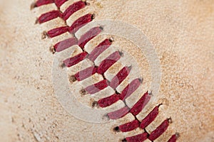 Close up macro view of red stitched seams of an worn baseball