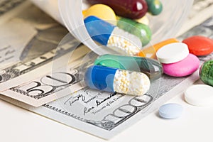 Close up and macrophotography of colourful capsules and tablets on us dollar banknotes, concept of pharmaceutical industry profita