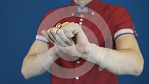 Close up magician in red shirt perform magic trick disappear in hands coin