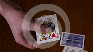 Close-up of a magician`s hands performing card tricks, making fan out cards on black background