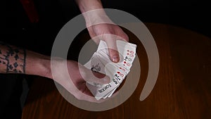 Close-up of a Magician`s Hands Performing Card Tricks, Making Fan Out Cards on black background