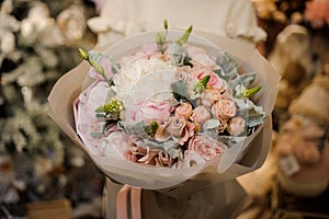 Close-up of magnificent bouquet of hydrangeas and peonies and roses wrapped in paper