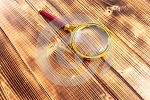 Close-up of a magnifier on a wooden background