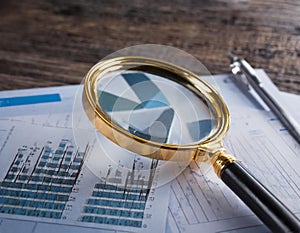 Close-up of a magnifying glass on financial charts and graphs