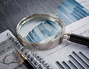 Close-up of a magnifying glass on financial charts and graphs